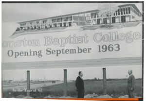 Two men stand by a sign announcing HCU's opening, with First President William H. Hinton pictured above "HCU" on campus.