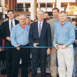 Edward D. Hodo and four men at a ribbon-cutting ceremony on HCU campus, crowd gathered in the background.