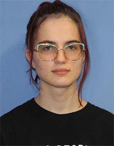 Evany Hancock wearing glasses against a blue background, seeking academic support at Houston Christian University.