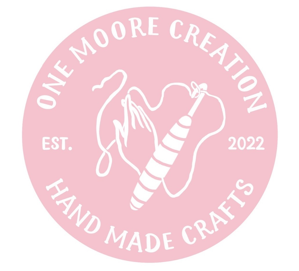 Pink circular logo for One Moore Creation Handmade Crafts Est. 2022, hand with yarn; featured in HCU alumni business directory.