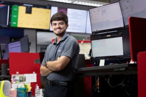 Finance student analyzes data on multiple monitors in the university trading lab.
