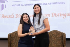 Two students accept a scholarship award during an Archie W. Dunham College of Business ceremony.