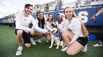 HCU athletes crouching next to Kiza.