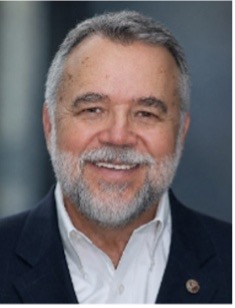 Smiling older man with gray hair and beard in suit jacket on HCU campus, representing Christ-Oriented entrepreneurship.