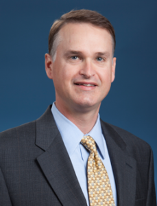 Tadd Tellepsen in a gray suit and patterned tie promotes the STEM Building Project leadership at Houston Christian University.