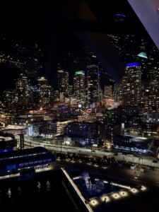 HCU campus glowing at night, skyscrapers shining in the distance, evoking celebration and achievement for Kinesiology grads.