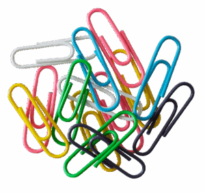 Assorted colorful paper clips of different sizes scattered on a white surface, useful for HCU student organization and study.