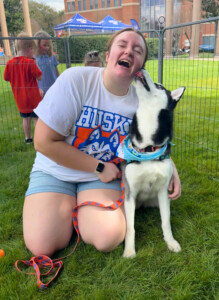 Sophia laughs as a husky licks her face on the Houston Christian University campus.