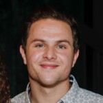 Young man with short brown hair in a light patterned shirt smiles, promoting HCU Apologetics on campus.