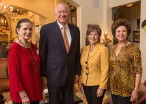 Four adults sharing coffee and conversation in a warmly decorated living room, enjoying a welcoming academic environment.