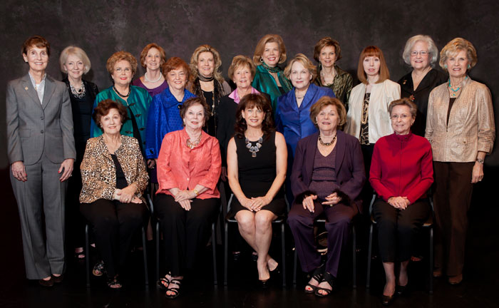 Nineteen women, some seated and others standing, pose together indoors in a ceremony honoring Guild Presidents.