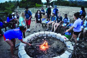 Students roasting s'mores around a campfire.